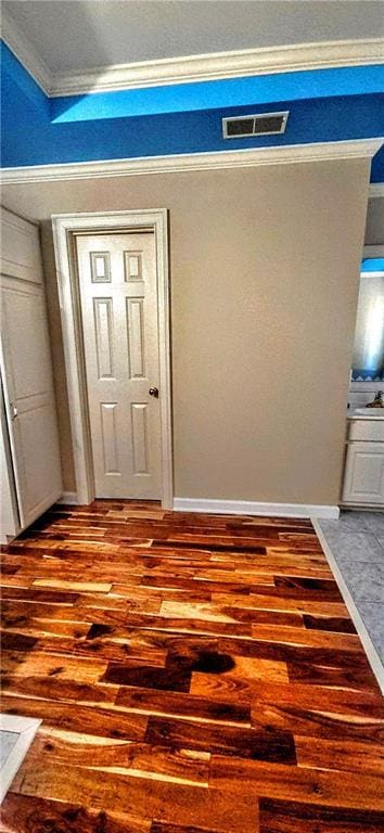 interior space with hardwood / wood-style floors, visible vents, and ornamental molding