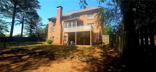 rear view of house featuring a chimney, a fenced backyard, and stairway