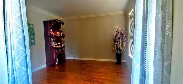 interior space featuring wood finished floors, crown molding, and baseboards