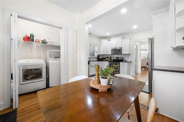 dining room with independent washer and dryer and light wood-type flooring