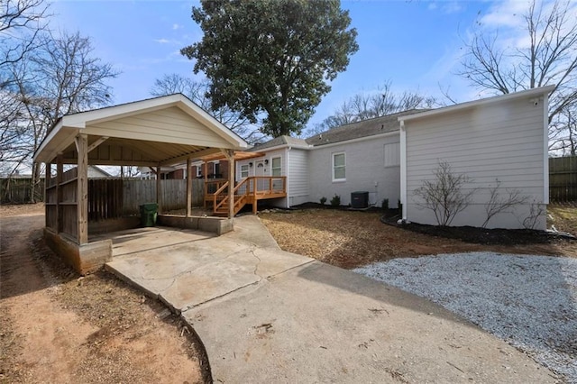 back of house with cooling unit and a carport