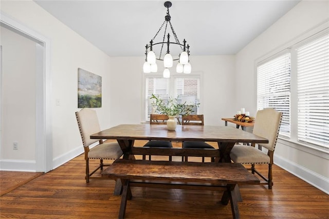 dining space with dark hardwood / wood-style flooring and a notable chandelier