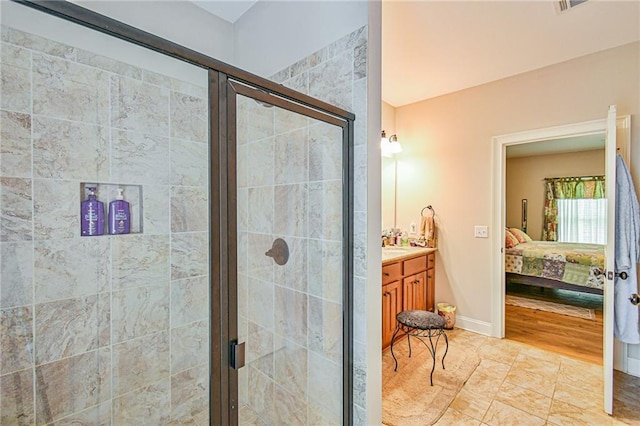 bathroom with hardwood / wood-style flooring, vanity, and a shower with shower door