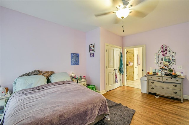 bedroom featuring light wood-type flooring, ensuite bathroom, and ceiling fan