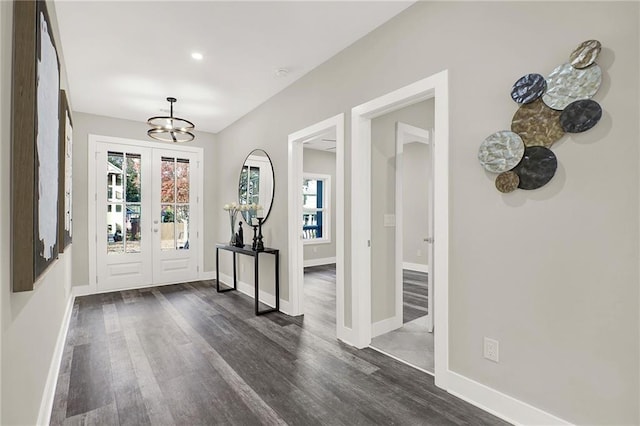 entryway with a notable chandelier and dark wood-type flooring