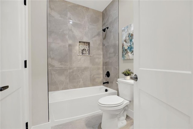 bathroom with toilet and tiled shower / bath