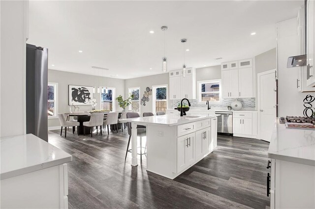 kitchen featuring white cabinetry, a center island with sink, dark wood-type flooring, and sink