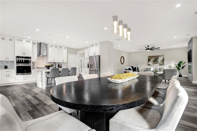 dining room with ceiling fan and dark hardwood / wood-style flooring