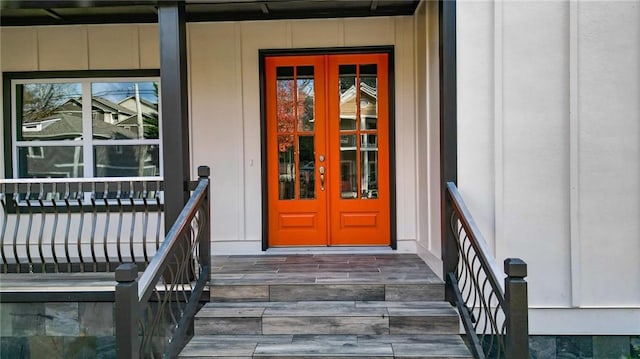 view of exterior entry featuring covered porch and french doors