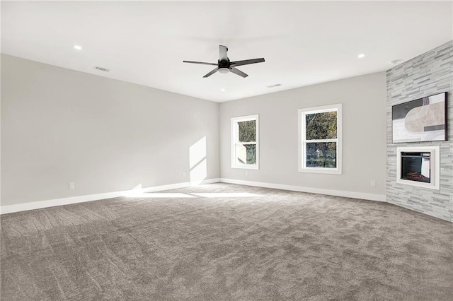 unfurnished living room featuring carpet, a large fireplace, and ceiling fan