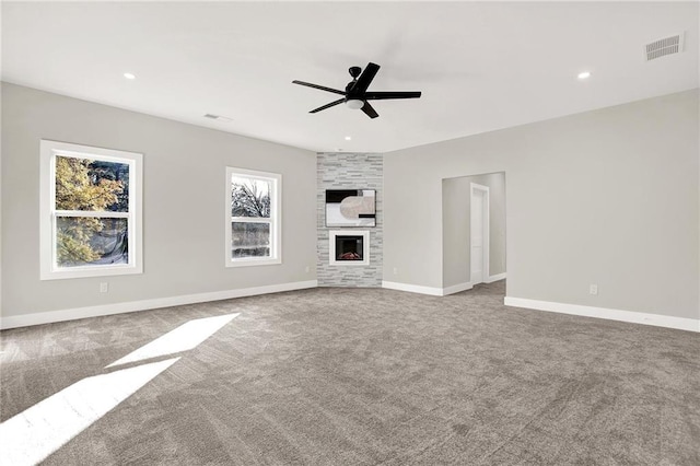 unfurnished living room featuring ceiling fan, a fireplace, and carpet floors