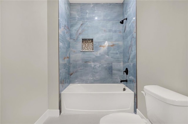 bathroom featuring toilet and tiled shower / bath