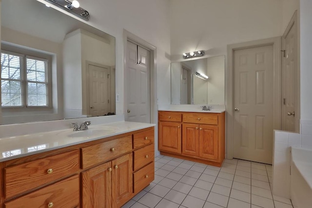 bathroom featuring vanity, a bath, and tile patterned floors