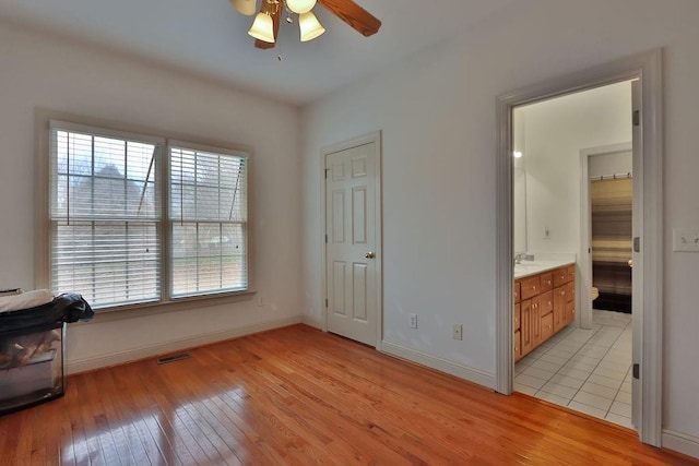 bedroom featuring ensuite bathroom, ceiling fan, a closet, and light tile patterned floors