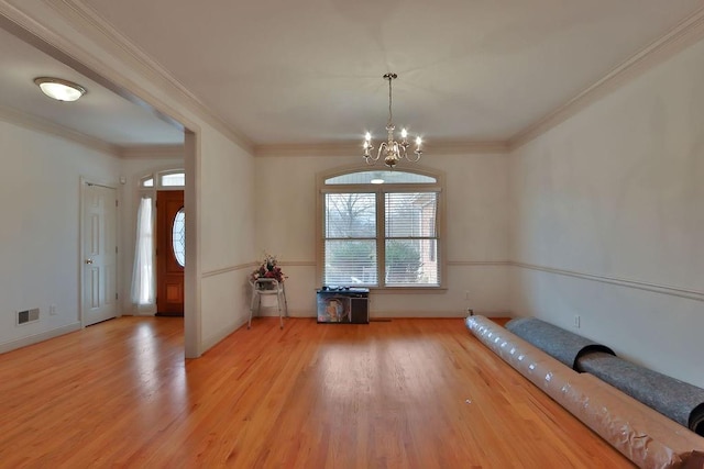 interior space with an inviting chandelier, crown molding, and light wood-type flooring