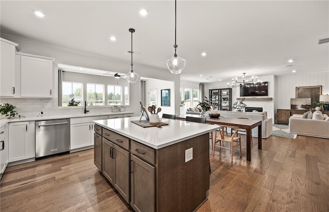 kitchen featuring a large fireplace, white cabinets, dark wood-type flooring, and dishwasher