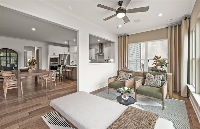 living room with ceiling fan, crown molding, and dark hardwood / wood-style floors