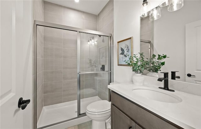 bathroom with toilet, walk in shower, and vanity