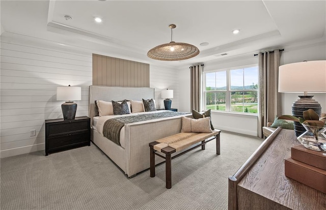 bedroom featuring ornamental molding, wood walls, a tray ceiling, and light carpet