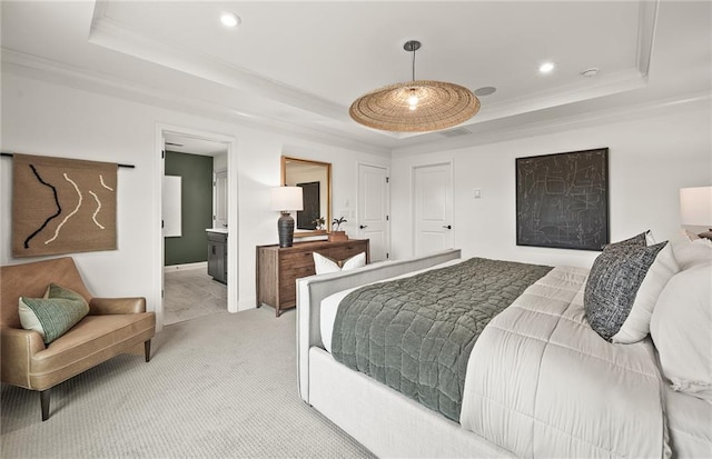 bedroom with ensuite bath, a raised ceiling, light colored carpet, and crown molding