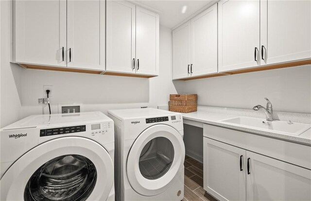 washroom featuring cabinets, washing machine and clothes dryer, and sink