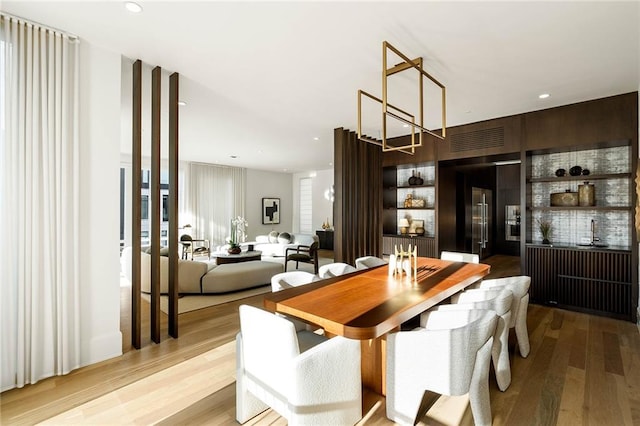 dining space featuring built in shelves and light hardwood / wood-style flooring