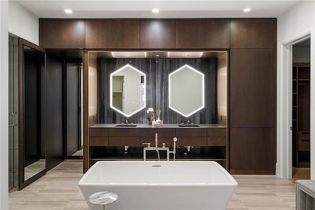 bathroom with a washtub and vanity