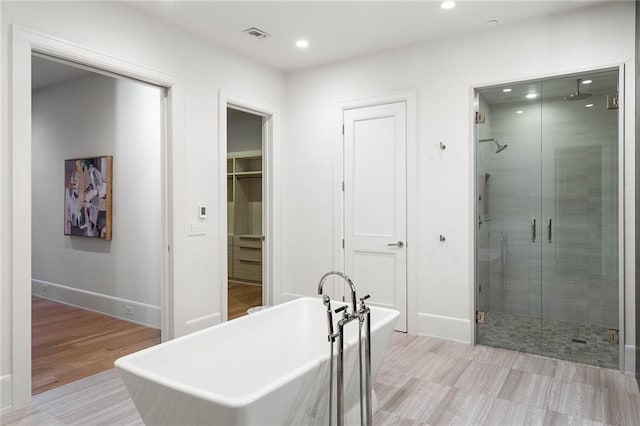 bathroom featuring hardwood / wood-style floors and separate shower and tub