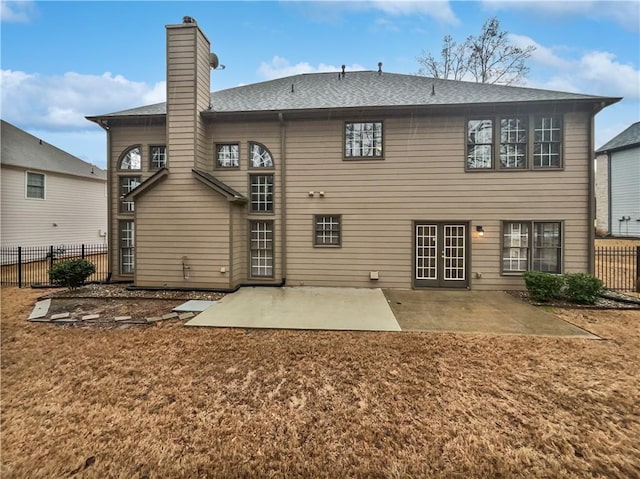 back of house featuring a patio area, a chimney, and fence