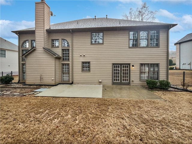 back of property with a patio area, fence, and a chimney