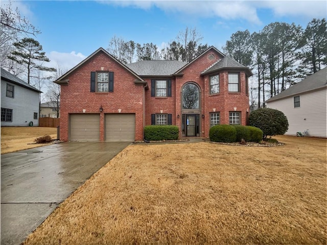 view of front of home with a garage, driveway, brick siding, and a front lawn