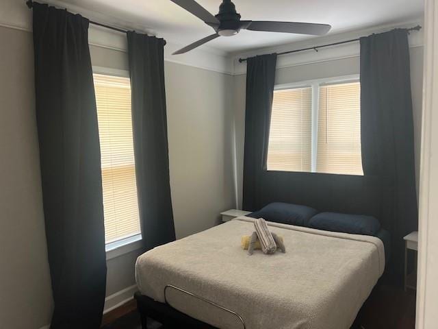 bedroom with ceiling fan and baseboards