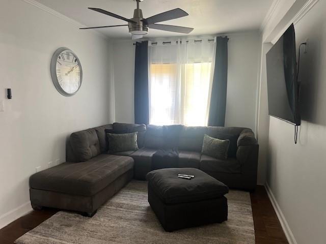 living area featuring ornamental molding, wood finished floors, a ceiling fan, and baseboards