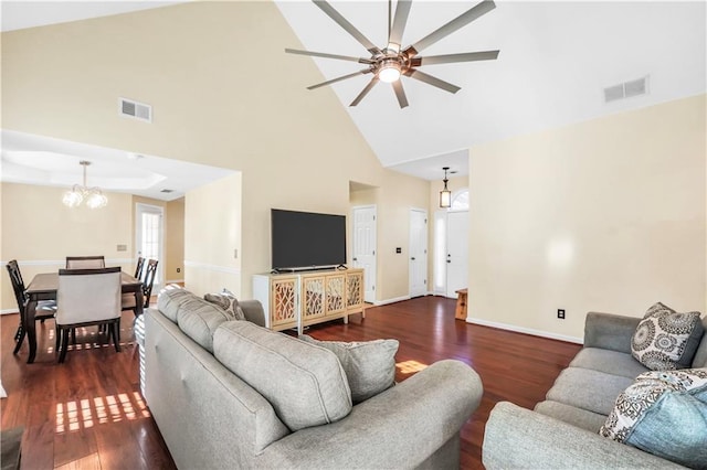 living area with ceiling fan with notable chandelier, visible vents, dark wood-style flooring, and baseboards