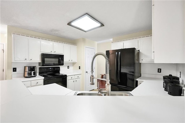 kitchen with white cabinetry, black appliances, light countertops, and a sink