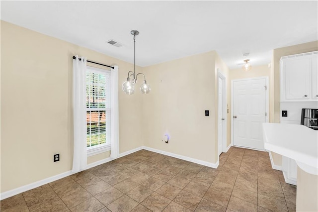 unfurnished dining area with a notable chandelier, baseboards, and visible vents