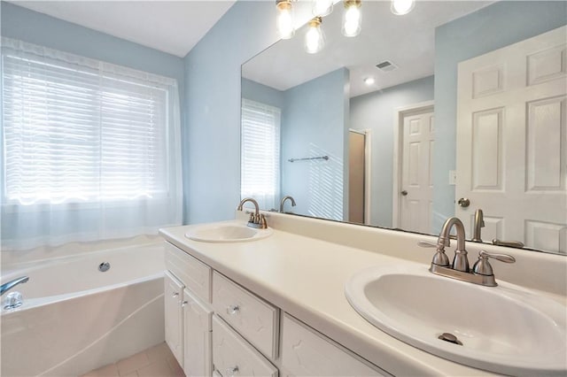 full bathroom featuring tile patterned flooring, double vanity, a garden tub, and a sink