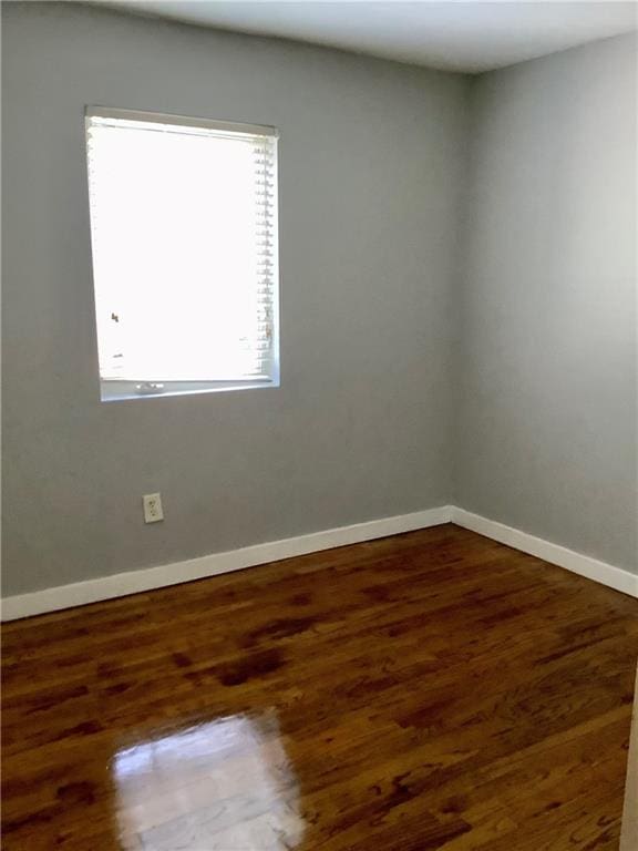 spare room featuring dark wood-type flooring