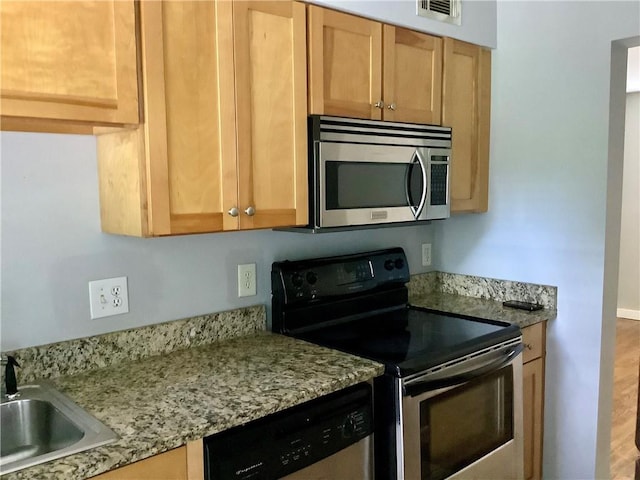 kitchen featuring light stone countertops, stainless steel appliances, hardwood / wood-style floors, and sink