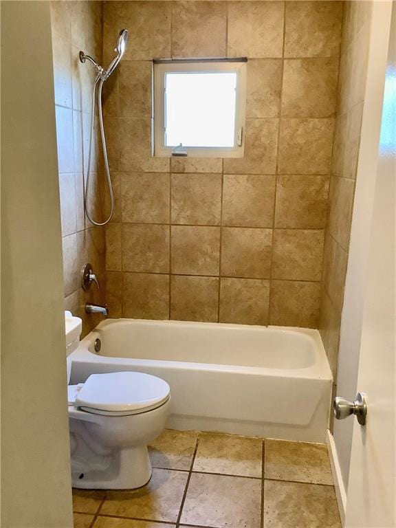 bathroom with tile patterned flooring, toilet, and tiled shower / bath