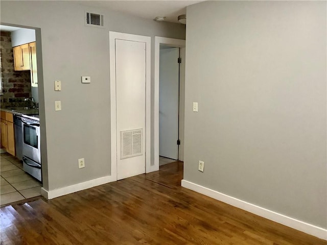 interior space with stainless steel stove, dark wood-type flooring, and sink