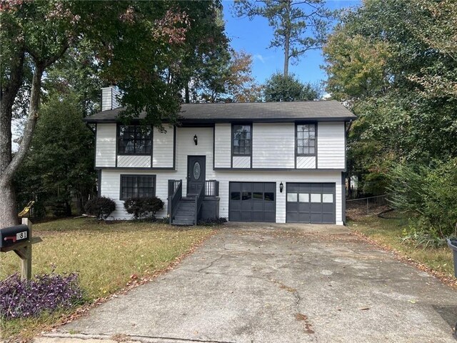 bi-level home with a garage and a front lawn