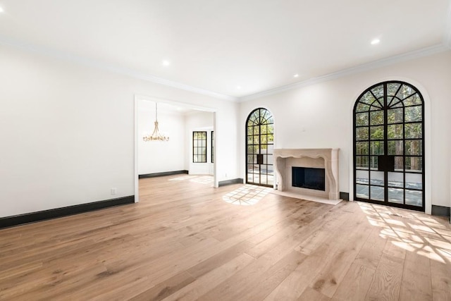 650 Moores Mill Rd NW Unit 1, Atlanta, GA 30327 - unfurnished living room with light wood-style flooring, a chandelier, a fireplace with flush hearth, ornamental molding, and recessed lighting