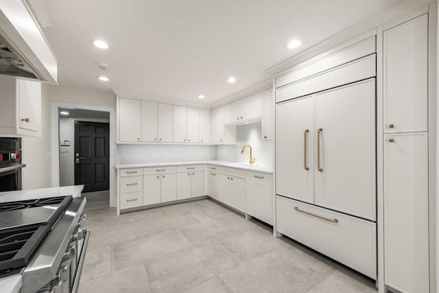 650 Moores Mill Rd NW Unit 1, Atlanta, GA 30327 - kitchen featuring range hood, white cabinets, light countertops, stainless steel gas stove, and paneled fridge