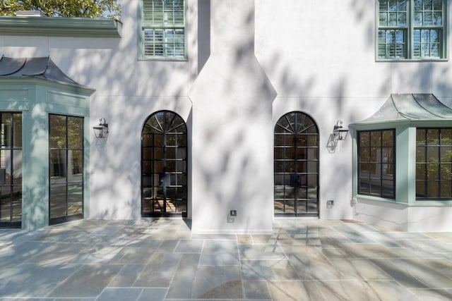 650 Moores Mill Rd NW Unit 1, Atlanta, GA 30327 - entrance to property featuring stucco siding, a patio, and a standing seam roof