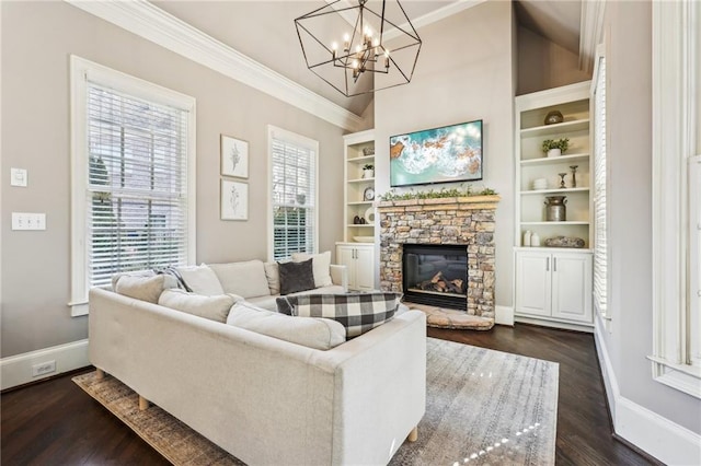 living room featuring built in shelves, baseboards, a stone fireplace, and ornamental molding