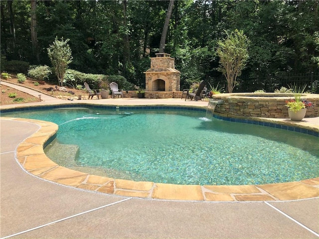 pool featuring a patio area and an outdoor stone fireplace