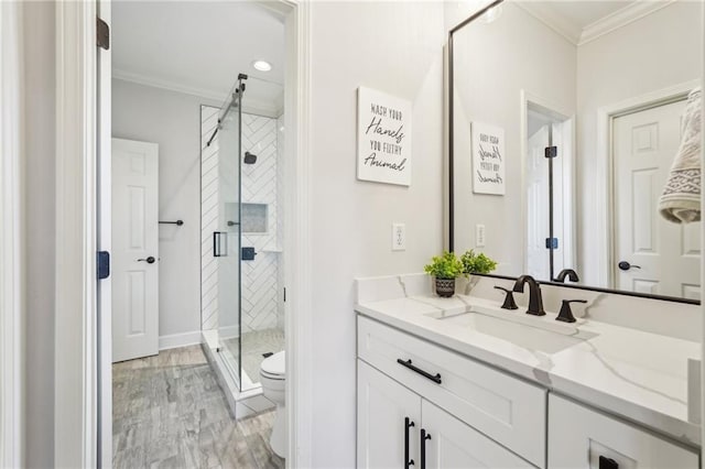 full bathroom featuring a stall shower, toilet, ornamental molding, and vanity