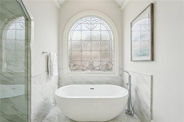 full bath featuring tiled shower, lofted ceiling, a soaking tub, and marble finish floor