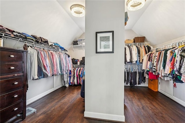 walk in closet with wood finished floors and vaulted ceiling